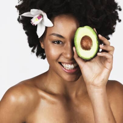 Woman with healthy skin eating an avocado