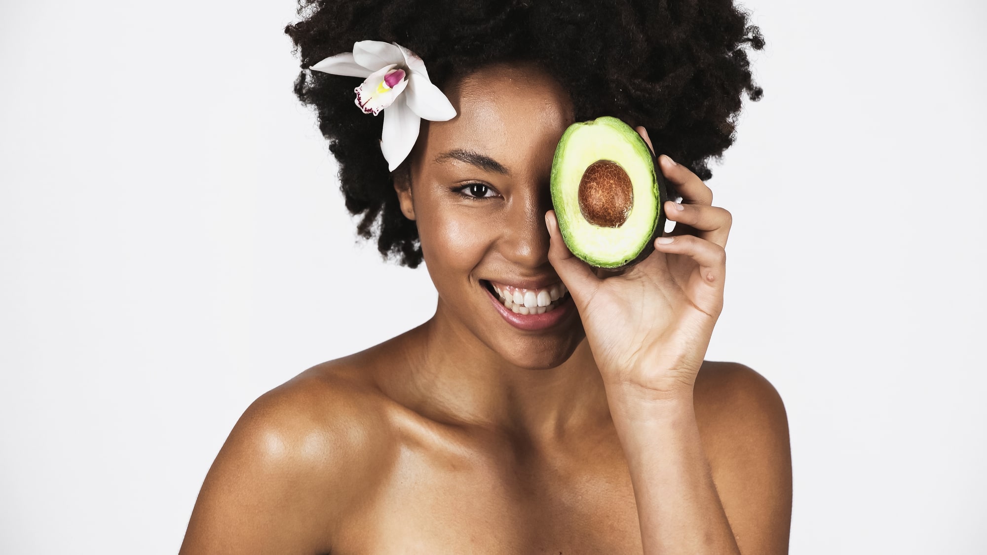 Woman with healthy skin eating an avocado